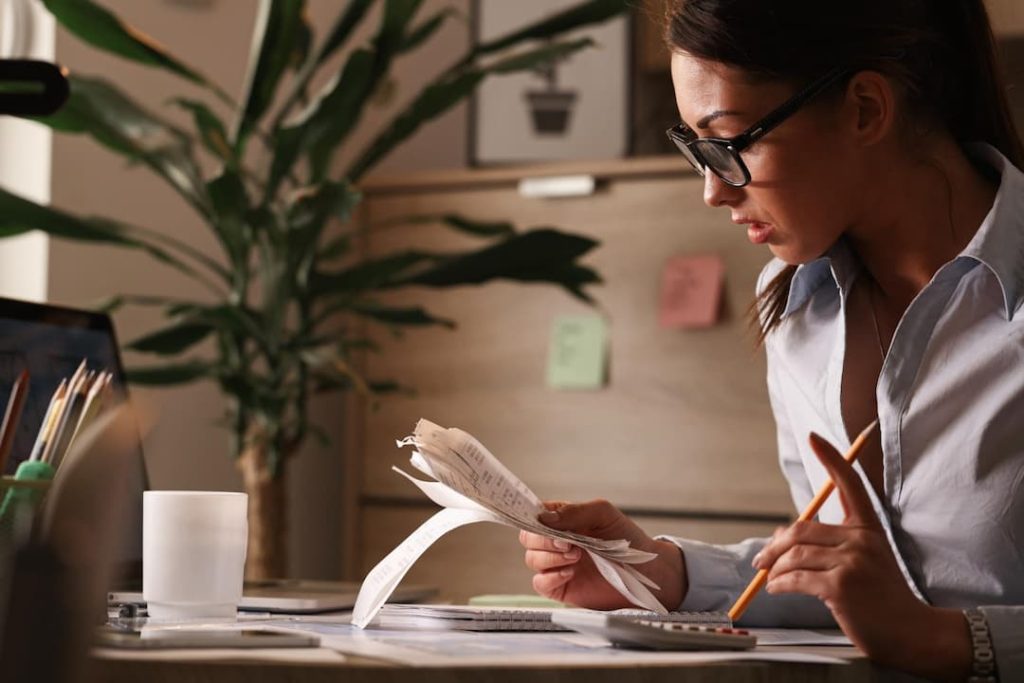 mujer con lentes leyendo facturas