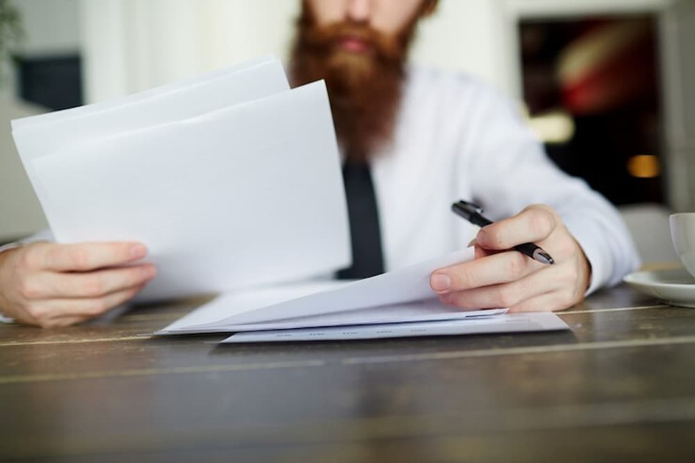Hombre con barba revisando documentos